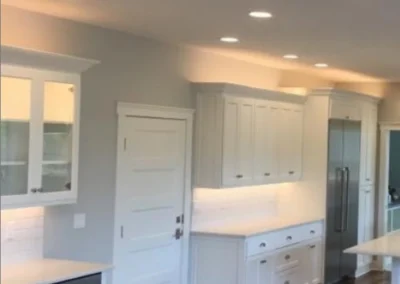 Recessed can lights in a hallway with white cabinets