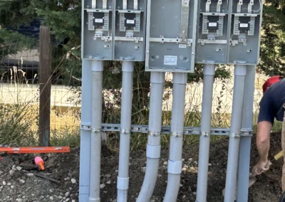 Gray meter pedestals with conduit runs at a job site